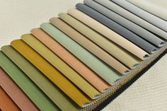 many different colors of fabric laid out on top of each other, with zippered ends