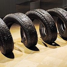 four tires are lined up in a row on the floor next to each other,