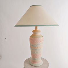 a lamp that is sitting on top of a table next to a white wall and floor