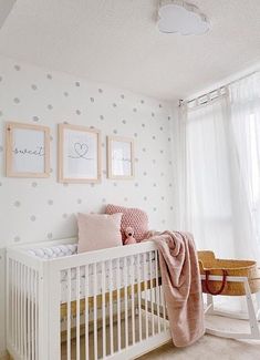 a baby's room with polka dot wallpaper and white crib