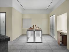 two sinks in a room with tiled flooring and wall to wall mirrors on the walls