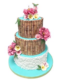 a three tiered cake with flowers on the top and bottom layer is decorated in wicker