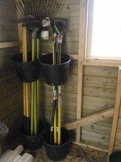 several buckets are stacked on top of each other in the corner of a shed