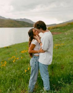 a man and woman standing next to each other in the grass