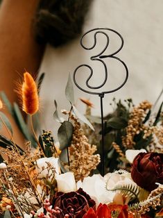 there is a wedding cake topper that has the number three on it and flowers