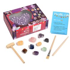 an assortment of rocks and wooden dows in a box next to a card game