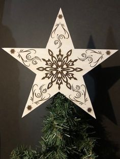 a wooden star hanging from the side of a christmas tree