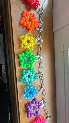 a bunch of different colored beads hanging on a wall next to a keychain