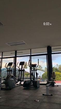 there are many treadmills in the gym with large windows looking out onto the water