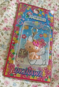 a hello kitty keychain with a pink bow on it's head in a package