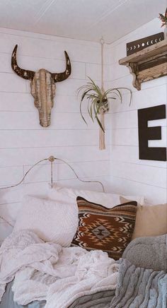 a bed room with a neatly made bed and cow head on the wall above it