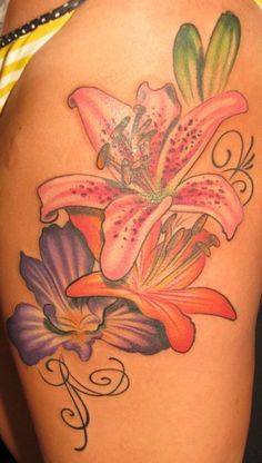 a woman's thigh with flowers on it and the word e written in cursive writing