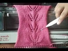 someone is knitting a pink knitted sweater with scissors and yarn in front of an oven