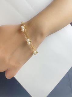 Our stunning bracelet is made of natural pearls connected with 14k gold filled cable chain, layered with 14k gold filled bead chain. The double layer design make this bracelet minimalist but elegant and surely eye-catching! Freshwater pearl size is 5mm Bracelet length is 18+4.5 As it's a handmade item please allow 2-3mm difference. Please let me know if you would like a different chain or length. Please keep them away from chemicals such as perfume, hairspray ect. Better remove before shower and swim.   The product is made by care and love 💕 White Pearl Bracelet With Adjustable Chain, Dainty Gold-plated Pearl Bracelet With Adjustable Chain, Dainty Gold Plated Pearl Bracelet With Adjustable Chain, Dainty Gold Plated Pearl Chain Bracelet, Dainty Rose Gold Pearl Chain Bracelet, White Pearl Drop Bracelet In 14k Gold Filled, White Gold Plated Pearl Bracelet With Pearl Drop, White Gold-plated Pearl Drop Bracelet, Delicate Pearl Chain Bracelet With Pearl Charm