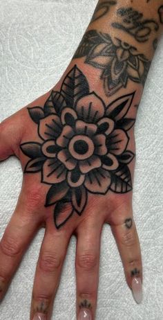 a woman's hand with a flower tattoo on it