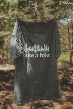 Take A Hike graphic t-shirt. Each t-shirt is pressed house on a comfort colors unisex shirt. T-shirts are made of a soft cotton blend and features a vibrant direct to fabric transfer design that won't fade or crack. COLOR PICTURED: HEMP Shop our wanderlust inspired t-shirt collection. Perfect for those who enjoy hiking, camping, exploring the outdoors and all adventure seeking enthusiasts. keywords: take a hike, outsider hiking shirt, wanderlust t-shirt, adventure t-shirts, graphic tees, unisex Take A Hike Shirt, Custom Print Short Sleeve T-shirt For Outdoor, Cotton Crew Neck T-shirt For Outdoor Activities, Green Graphic Print T-shirt For Camping, Green Graphic Tee For Outdoor, Green T-shirt For Outdoor Activities, Outdoor Cotton T-shirt With Graphic Print, Pre-shrunk Green T-shirt For Camping, Cotton Graphic Print T-shirt For Outdoor