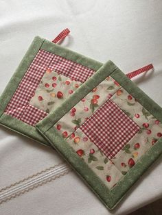 two quilted place mats sitting on top of a bed