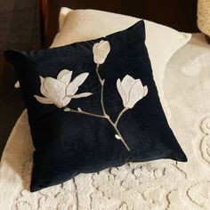 a black pillow with white flowers on it