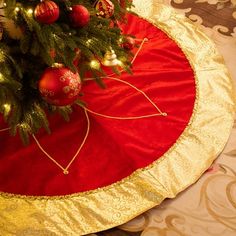 a christmas tree skirt on top of a red round tablecloth with ornaments around it