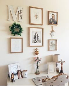 a white desk topped with lots of framed pictures