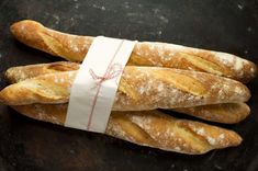 four loaves of bread sitting on top of a black plate