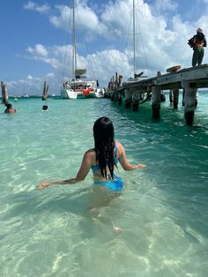 a woman is in the water near a dock