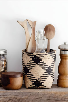 wooden spoons, salt and pepper shakers in a woven basket on a shelf