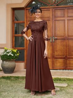 a woman standing in front of a door wearing a brown dress