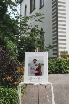 an easel with a photo on it in front of a building