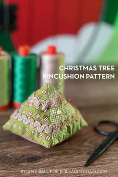 christmas tree pincushion pattern with scissors and spools of thread in the background