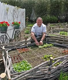 a man kneeling down in the middle of a garden