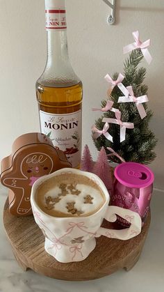 a cup of hot chocolate next to a bottle of booze on a wooden tray