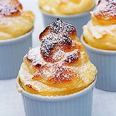 small cupcakes with powdered sugar on top are lined up in blue cups