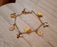 A gold colored charm bracelet made with enamel bee and flower charms, and metal butterfly charms. Made with iron, nickel-free hardware. Adjustable. Bracelet Breloques, Bee And Flower, Metal Butterfly, Bee Charms, Bracelet Charm, Butterfly Charm, Flower Bracelet, Flower Charm, Adjustable Bracelet