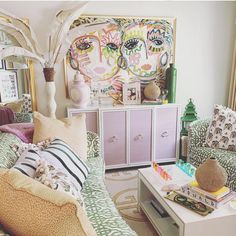 a living room filled with lots of furniture next to a painting on the wall above a coffee table