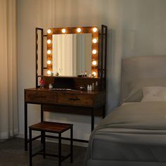 a vanity with lights on it and a bed