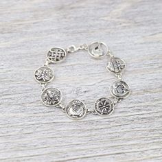 This sterling silver charm bracelet is a great way to accessorize and carry something incredibly meaningful with you throughout the day. Each charm depicts one of the 8 Auspicious Symbols, also known as the "Ashtamangala" in Sanskrit. "Ashta" meaning "eight," and "mangala" meaning "auspicious." Handmade by a fair-trade group of silversmiths in Nepal, this detailed bracelet is finished with a lobster clasp. In Buddhist legend, the 8 Auspicious Symbols represent offerings the gods made to the Budd Spiritual Good Luck Jewelry Bracelet, Symbolic Sterling Silver Charm Bracelet, Amulet Bracelet Jewelry As Gift, Symbolic Silver Bracelet Jewelry, Amulet Bracelet Jewelry Gift, Symbolic Silver Bracelet, Silver Symbolic Bracelet, Amulet Style Bracelet Jewelry Gift, Nickel Free Metal Charm Bracelet - Spiritual Style