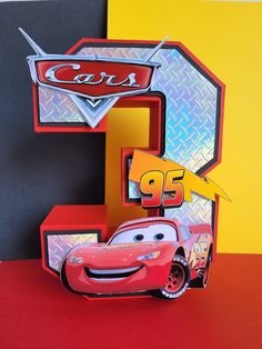 the letter e is made out of paper and has cars on it's side