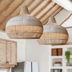 two wicker lamps hanging from the ceiling in a kitchen