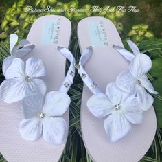 a pair of white flip flops with flowers on them