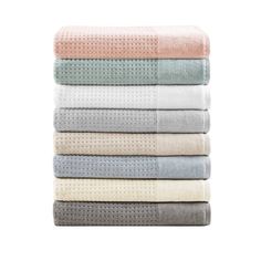 four towels stacked on top of each other in various colors and patterns, with one folded