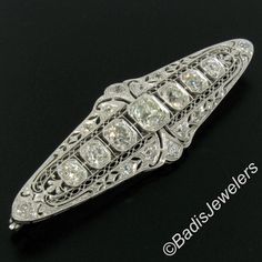 "Here we have a stunning diamond brooch crafted in solid platinum during the art deco period. It features 7 large old European cut diamonds which are bead set in elegantly milgrain-etched octagonal shape baskets. The brooch is then drenched with petite old mine cut diamonds which total approximately 1.20 carats, beautifully accenting this piece along with the finest etching work and filigree designs showcasing the masterful workmanship used during the art deco period. The center diamond is a lar Classic Brilliant Cut Brooch For Anniversary, Classic Brilliant Cut Brooches For Anniversary, Classic Diamond White Brooch For Anniversary, Classic Diamond White Brooches For Anniversary, Classic Platinum Brooch For Anniversary, Classic Platinum Brooches For Anniversary, Silver Anniversary Brooches With Single Cut Diamonds, Anniversary Brooches With Single Cut Diamonds In Diamond White, Classic Wedding Brooch With Brilliant Cut