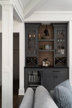 a living room filled with furniture and lots of storage under the shelves on the wall