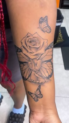 a person with a rose and butterflies on their arm