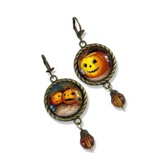 I made these earrings in my home studio in Marshall,MI.  My love for vintage Halloween is endless and I just adore this image from an old Victorian postcards. They feature our happy Victorian Jack 'o Lanterns all ready for the Halloween season.  The settings are finished in antique bronze tone that are 1 inch wide. The images are .8 inches and are set under glass cabochons. The settings have a nice braid detail around the edge with a variegated pumpkin orange Czech glass beads attached at the bottoms.  Bead caps top the beads and give a finishing touch. The total length of the earrings is 2.5 inches. You can choose the style of ear hook at check out. Your earrings will be lovingly packaged and come in a gift box. * Please note that these earrings can be a bit heavy if you are not used to l Victorian Postcards, Lantern Earrings, Mismatch Earrings, Earrings Fall, Earrings Halloween, Pumpkin Earrings, Cool Braids, Mismatched Earrings, Halloween Earrings