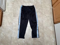 These pants are super hip and comfortable. They are killer Nike track pants from the 2000's. They are old school Nike. They is some pilling on the front, and the drawstring is kinda messed up, see the last photos. Still very wearable. They must be bought to be worn.  Brand: Nike Size: Medium Material: Polyester Measurements in inches Waist 30-34 Inseam 31 14.3 #26 I do accept returns within 30 days of purchase of all vintage items. The item must be in the same condition in which it shipped and preferably with the tags still on. The customer is responsible for all shipping costs and there is a 20% restocking fee for all returns. Vintage Nike Pants, Nike Hose, Nike Track Pants, Nike Vintage, Nike Pants, Mens Trousers, Pants Black, Vintage Nike, Track Pants