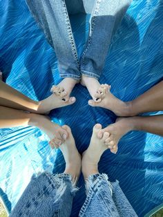 four people are sitting in a circle with their feet on each other's legs