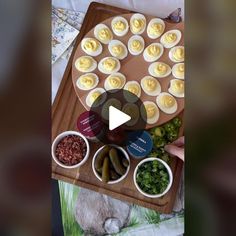 a wooden tray topped with lots of food next to bowls filled with different types of toppings