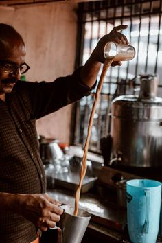 a man pouring something into a metal cup