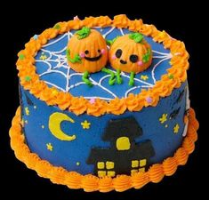 two pumpkins sitting on top of a blue cake